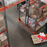 Overhead image of two workers in a warehouse amongst inventory.