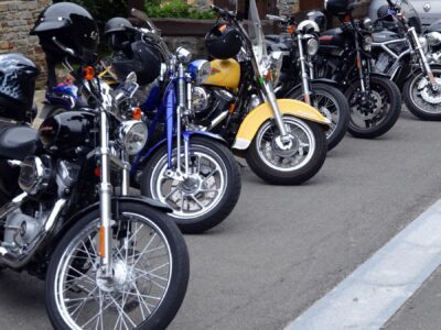 A row of parked motorcycles with helmets on the handlebars, as a visual representation of how Acumatica helps motorcycle businesses connect with customers and suppliers worldwide.