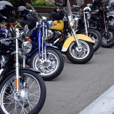 A row of parked motorcycles with helmets on the handlebars, as a visual representation of how Acumatica helps motorcycle businesses connect with customers and suppliers worldwide.